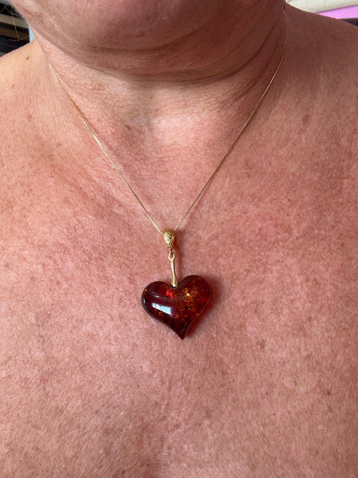 Collana ciondolo cuore di ambra rossa montata in argento dorato